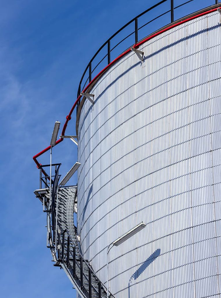 Oil storage tanks with blue sky background, Industrial tanks for petrol and oil, White fuel storage tank against blue sky.